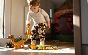 A toddler boy playing with dinosaur toys