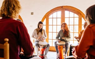 Smiling friends playing bongo at music therapy