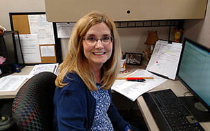 Sherry Saltsman smiling in her cubicle