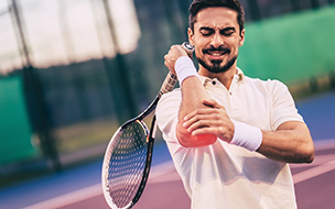 tennis player clutching elbow