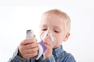 boy using an asthma inhaler with a mask