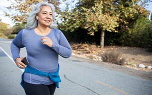 A mature Mexican woman jogging on a trail