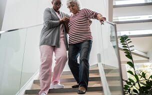 Nurse helping a senior woman walking down the stairs