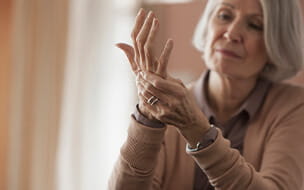 Senior Caucasian woman rubbing her hands.