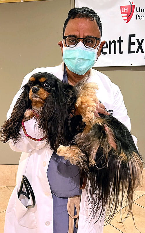 Dr. Gupta holds a dog at UH Portage Medical Center