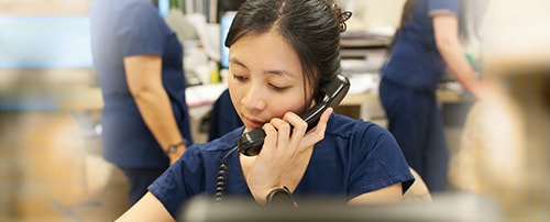 A Cancer Nurse taking into a telephone receiver