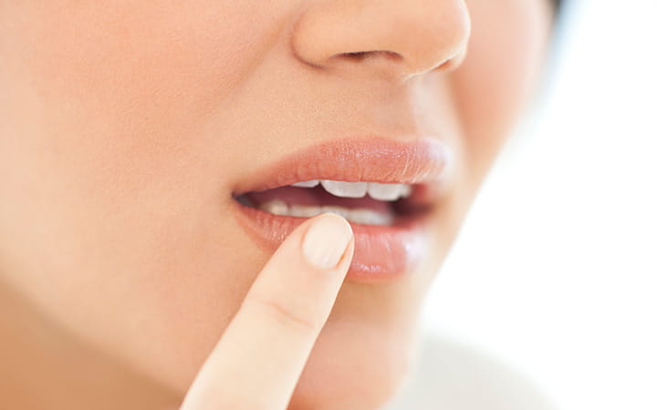 woman touching index finger to lip