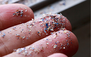 Close up of microplastics spread on fingertips