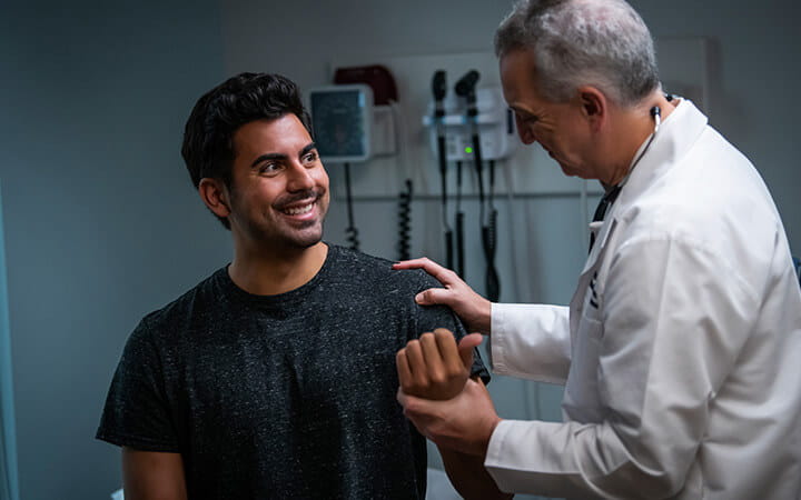 A happy man being examined by an older physician