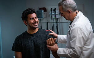 A happy man being examined by an older physician
