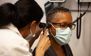 Doctor examining woman's ear