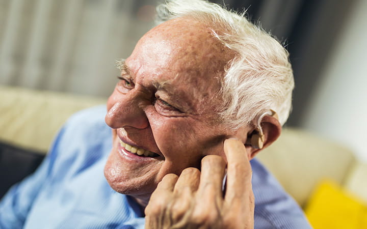 smiling older man with hearing aid