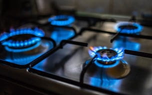 Closeup view of the four lit hobs of a gas stove