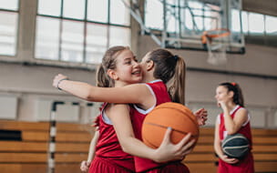 Girl-basketball-players-hugging-on-court