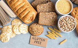 Various gluten free pasta, bread, snacks and flour on light gray background