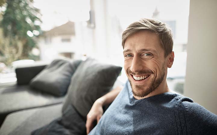 smiling young man sitting on couch