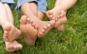Several pairs of bare feet in the grass
