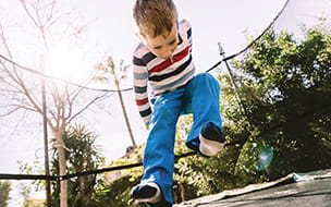 young boy jumping on trampoline