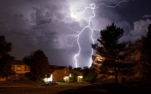 Lightning flashes over a neighborhood at night