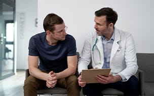 A mature doctor discussing a vasectomy with a male patient