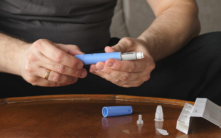 A man preparing a Semaglutide Ozempic injection to control his blood sugar levels