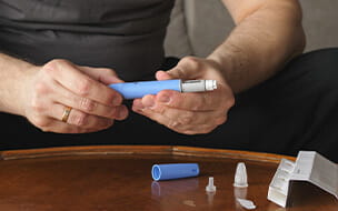 A man preparing a Semaglutide Ozempic injection to control his blood sugar levels