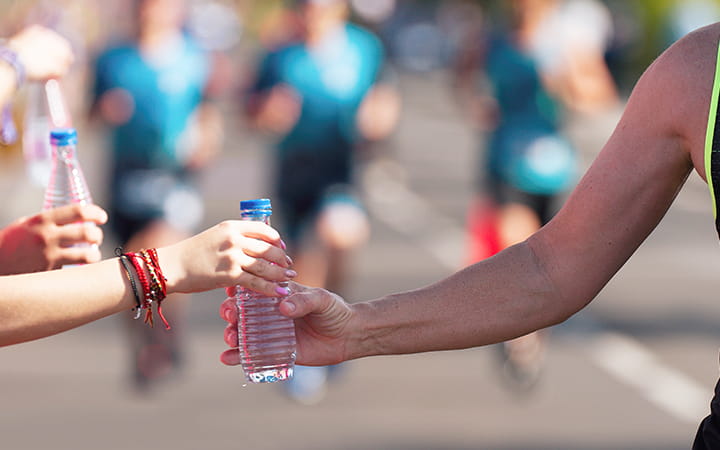 closeup of handing off water bottles during a race