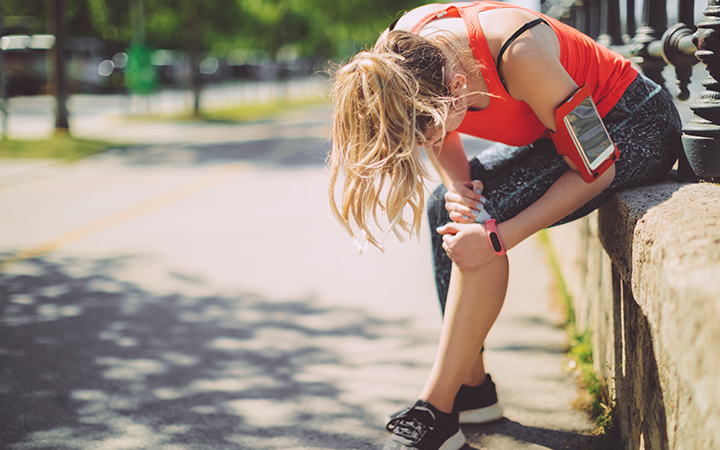Female runner bent over grasping knee