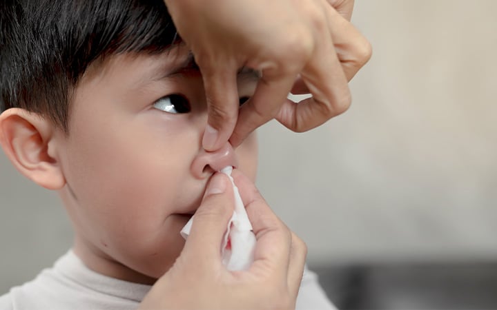 Mother caring for son's bloody nose