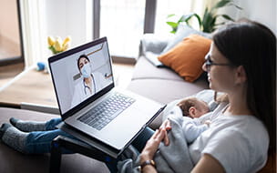 Mother and newborn baby at computer