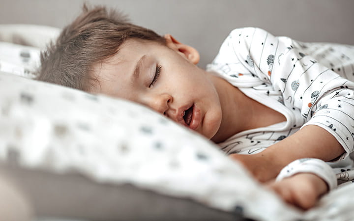 little boy sleeping on his side with mouth open