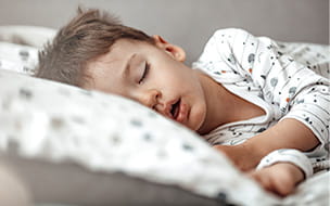 little boy sleeping on his side with mouth open