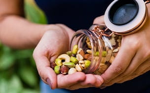 Woman pouring a variety of nuts into her hand