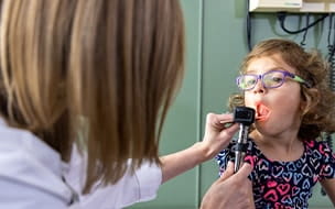 Pediatrician examines a young girls mouth