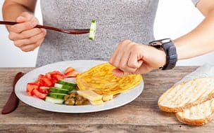 Person with plate of food looking at watch