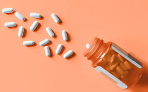 White pills spilling out of prescription bottle