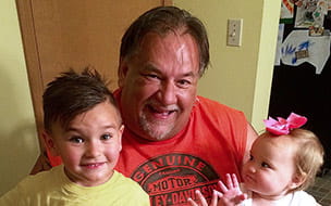 Dale Kline holds two young grandchildren