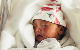 swaddled newborn wearing cap