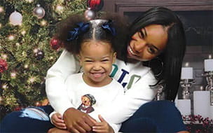 Jimisha Sailes and her daughter in front of their Christmas tree
