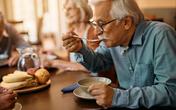 Older man enjoying a bowl of soup
