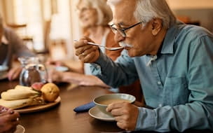 Older man enjoying a bowl of soup