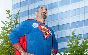 Andy "Superman" Simon poses triumphantly outside UH Seidman Cancer Center