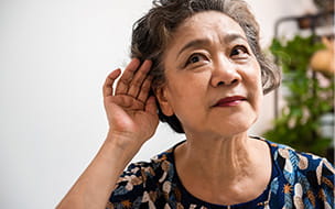 older woman with hand cupped to her ear
