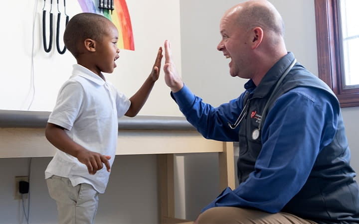 Kevin Turner, MD gives his young patient a high five