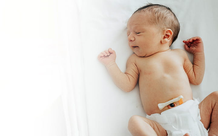 newborn lying on its back wearing diaper