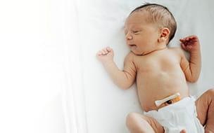 newborn lying on its back wearing diaper