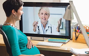 pregnant woman chats with doctor on a computer
