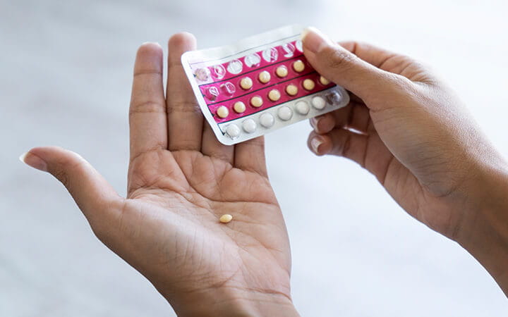 hands holding birth control pills