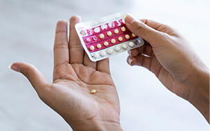 hands holding birth control pills