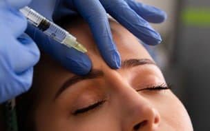 woman receives Botox injection in forehead